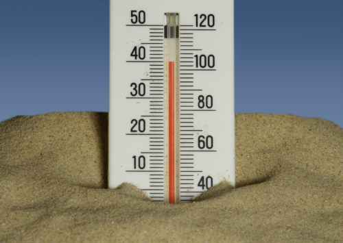 Thermometer at high temp sticking out of sand